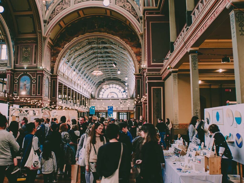 A crowd of people walking among expo booths