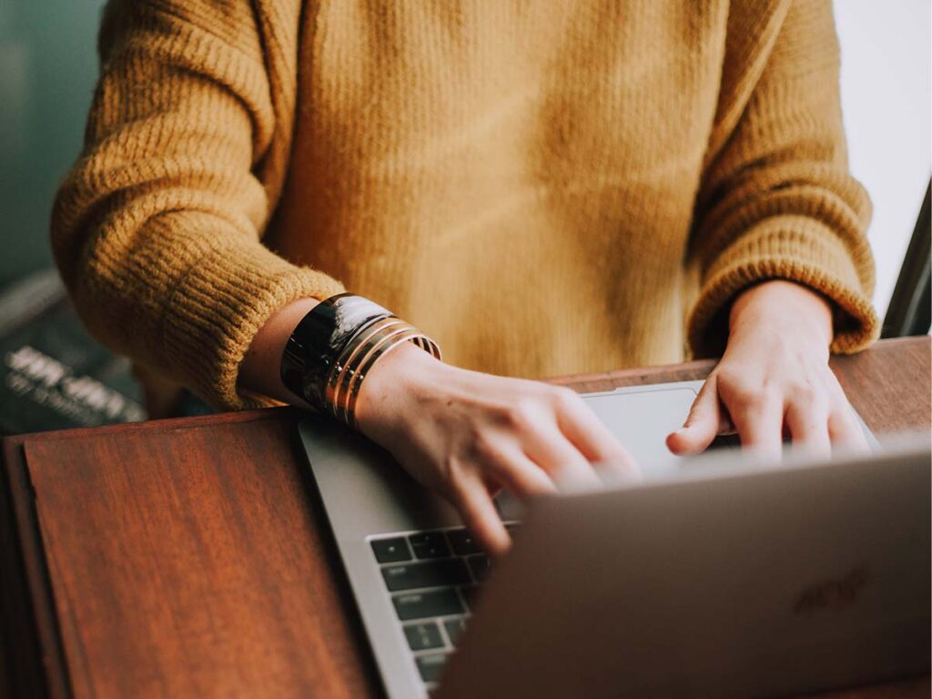 A person sitting at a table with a laptop.