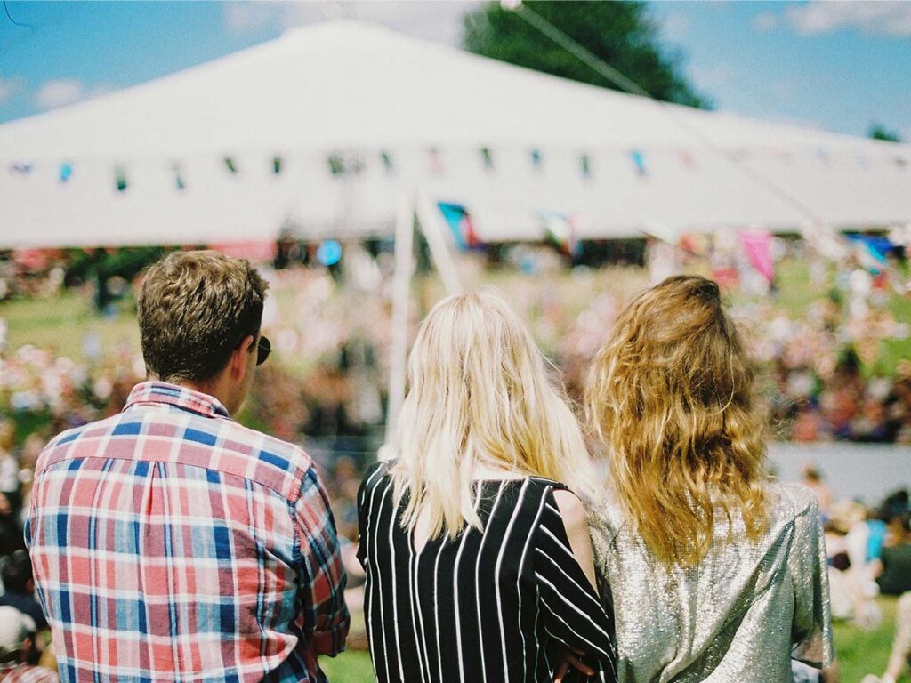 Three people standing in front of a tent.