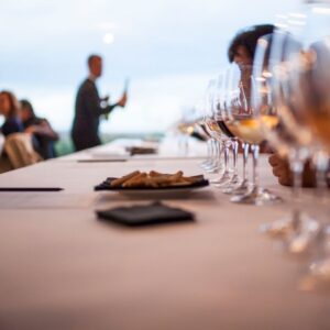 A group of people sitting at tables with wine glasses.