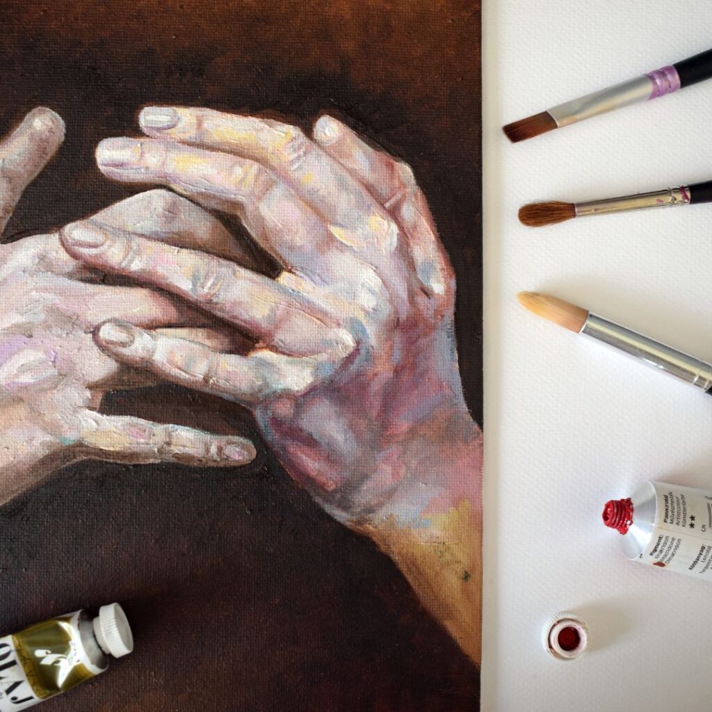 A painting of two hands with white paint on them.