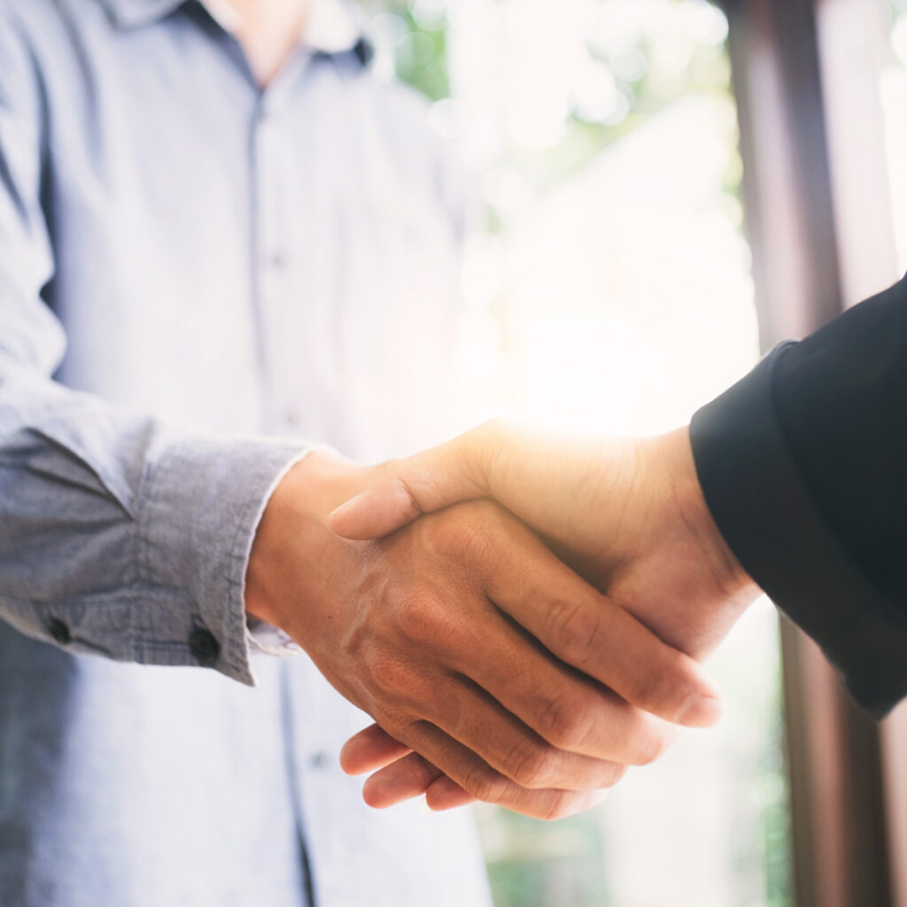 Two people shaking hands in a room.