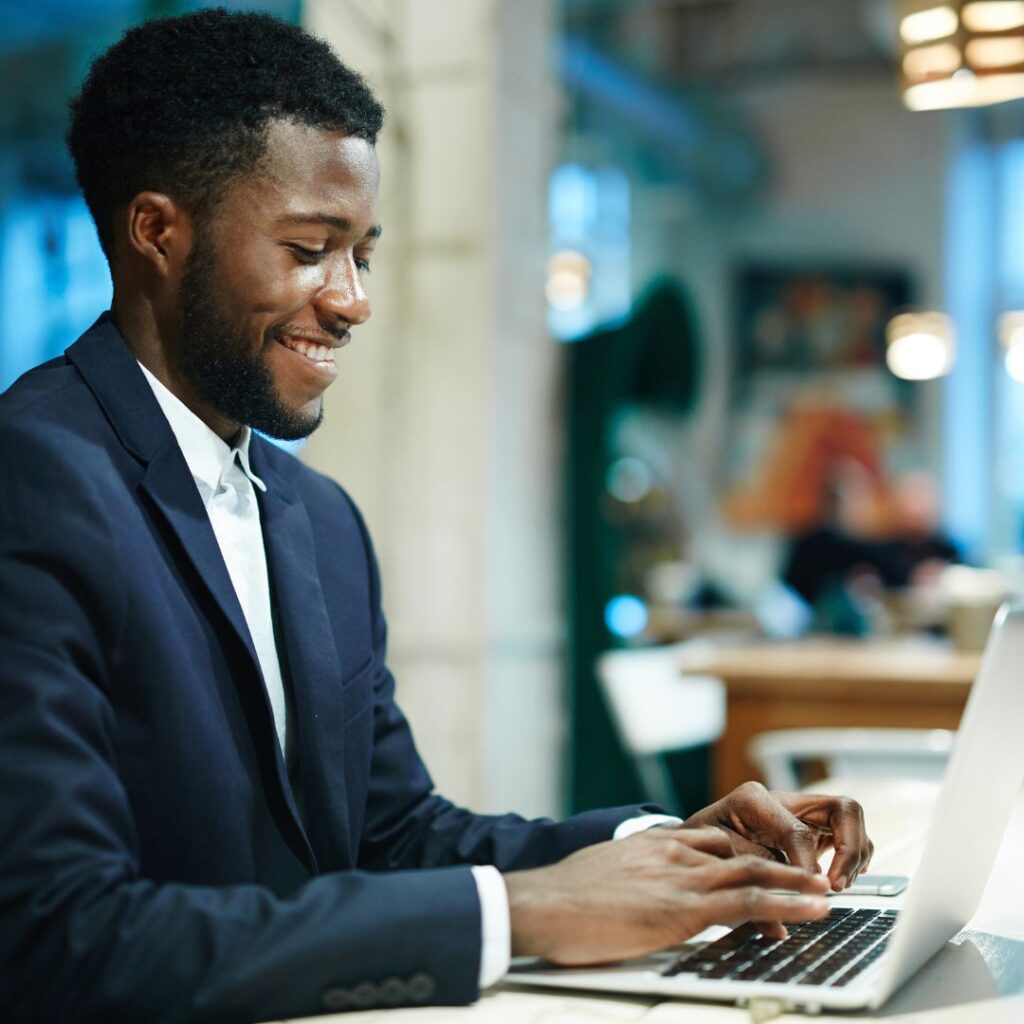 A man in suit and tie using a laptop.