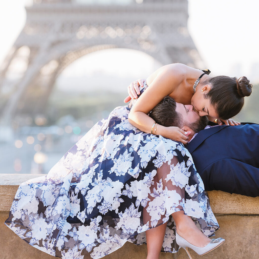 A couple kissing on a wall by the Eiffel Tower